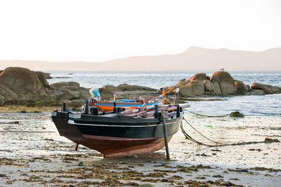 Boat moored on shore against sky