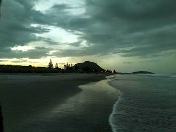 Scenic view of beach against dramatic sky