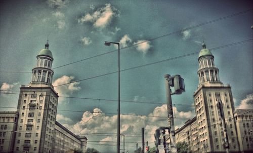 Low angle view of buildings against cloudy sky