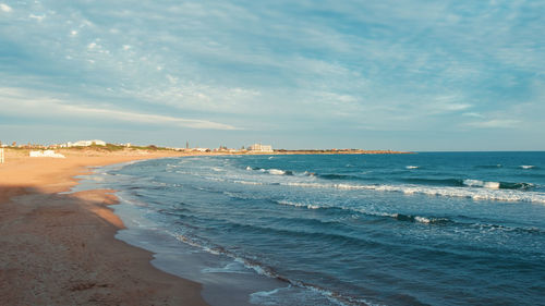 Sea waves come to the shore at sunset