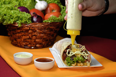 Cropped hand of person preparing food on table