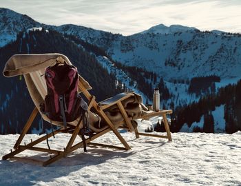 Chairs on snow covered mountain