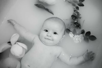 Portrait of cute baby girl in bathtub at bathroom