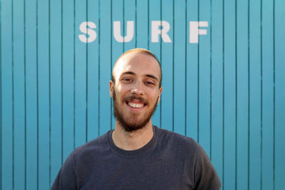 Portrait of young man standing against wall