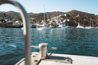 Sailboats moored in sea against sky