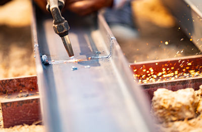A skilled metalworker using a gas torch to cut through steel. precision, craftsmanship, and inherent