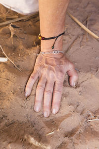 High angle view of hands on sand