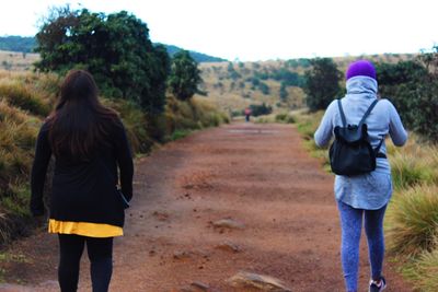 Rear view of couple walking on road