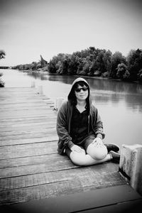 Portrait of woman sitting by lake