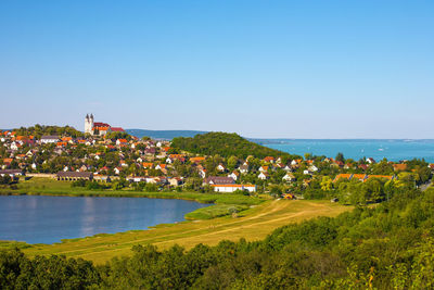 Scenic view of sea and city against clear blue sky