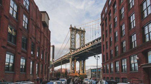 Low angle view of bridge and buildings against sky