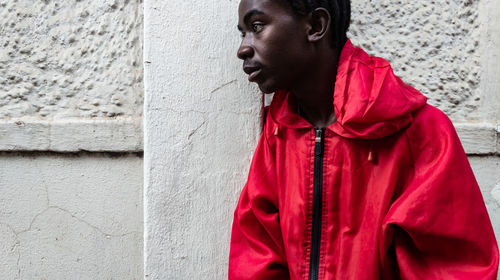 Portrait of young man standing against wall