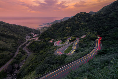 High angle view of light trails on road against sky during sunset