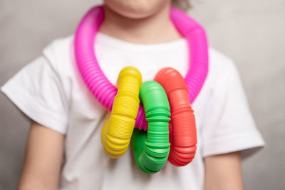 Midsection of child wearing plastic toy necklace