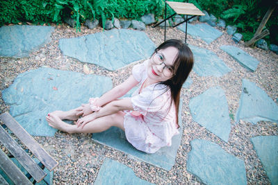 High angle view of young woman sitting outdoors