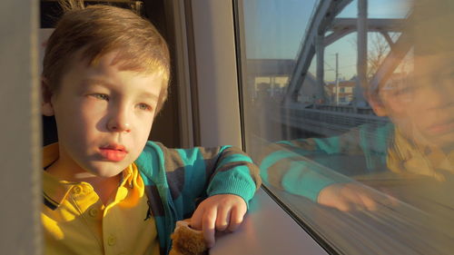 Portrait of boy looking through window