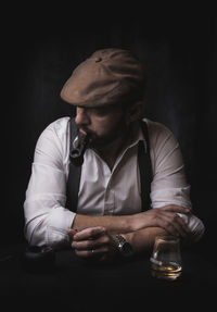 Side view of man using mobile phone while sitting on table