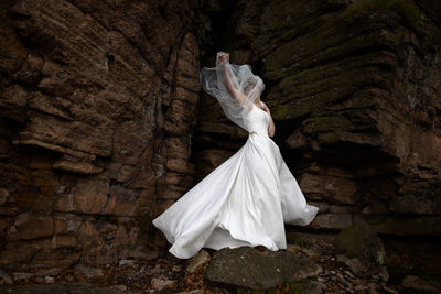 Rear view of woman standing on rock