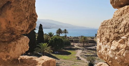 Scenic view of sea and mountains against clear sky