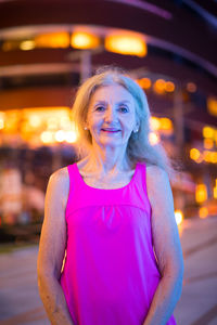 Portrait of smiling mid adult woman standing at night