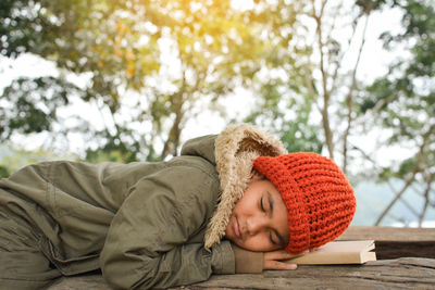 Boy sleeping with book on bench