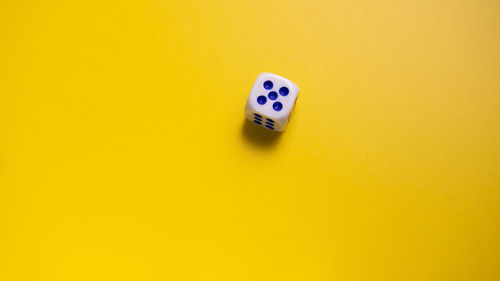 High angle view of arrow symbol on yellow table