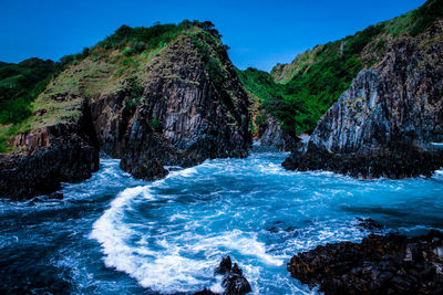 Scenic view of rocks in sea against sky