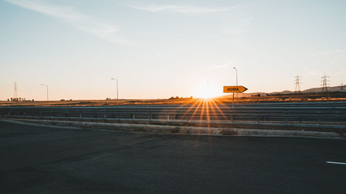 Road against sky during sunset in city