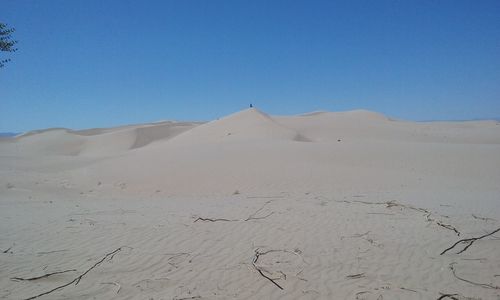 Scenic view of desert against clear blue sky