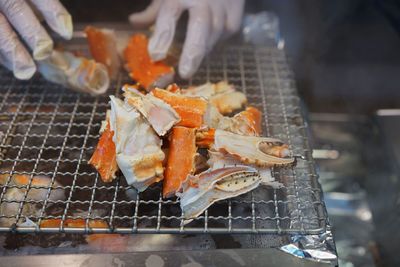 Close-up of person preparing food on barbecue grill