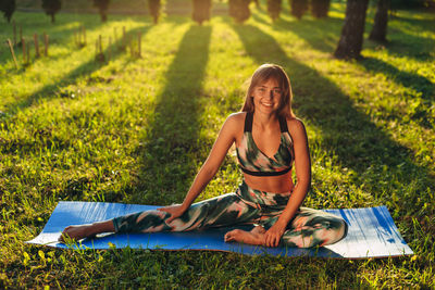 Portrait of smiling young woman lying on field