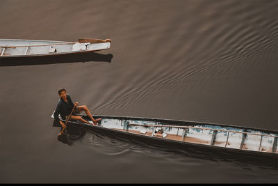 High angle view of man sitting in boat on sea