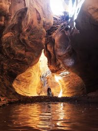 Man standing on rock formation in water