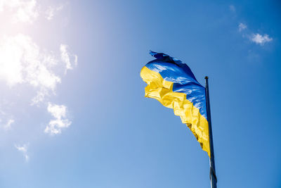 Ukrainian flag in the wind on blue sky background. large national yellow blue flag of ukraine. big