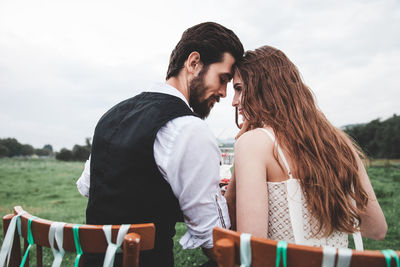 Rear view of wedding couple falling in love at farm