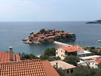 High angle view of townscape by sea against sky