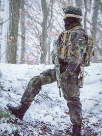 Rear view of man standing on snow covered field