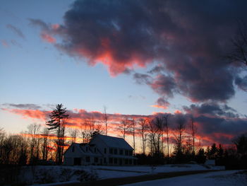 Silhouette houses against sky during winter