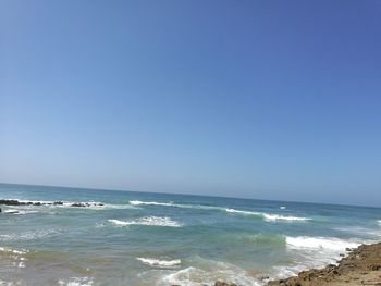 Scenic view of sea against clear blue sky