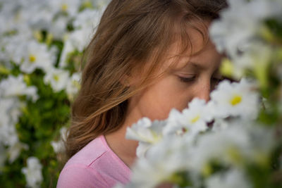 Close-up of girl amidst white flowers