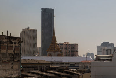 Buildings in city against clear sky