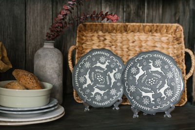 Celebratory plates with christmas pattern stand on a shelf with kitchen utensils