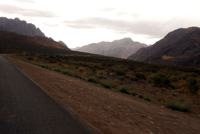 Scenic view of road and mountains against sky