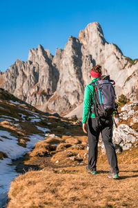 Woman hiking on footpath in alpine landscape in autumn, bischofsmütze, filzmoos, austria