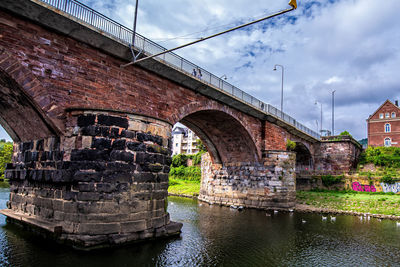 Arch bridge over river against sky