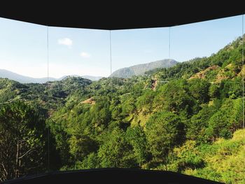 Scenic view of trees and mountains against sky