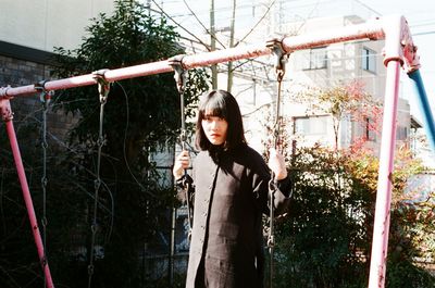 Portrait of serious young woman on swing