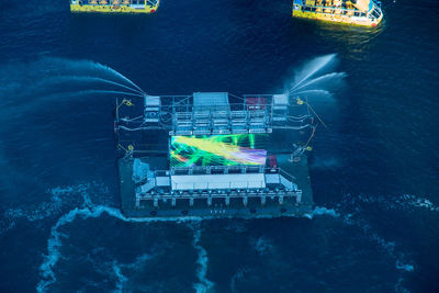 Digital composite image of illuminated ship in sea at night