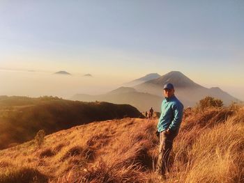 Man standing on mountain against sky