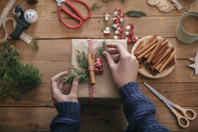 Woman's hands decorating christmas present